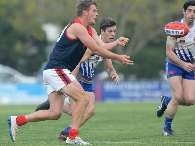 Sam Gibson dishes off a handball in his comeback game. Picture: Chris Eastman/AAP