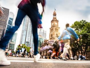 Sydney downtown, blurred intersection people and traffic in a sunny day at dusk