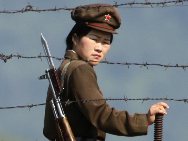 A North Korean soldier looks out from behind a barded wire fence around a camp on the North Korean river banks across from Hekou, northeastern China's Liaoning province. Picture: AP /Ng Han Guan