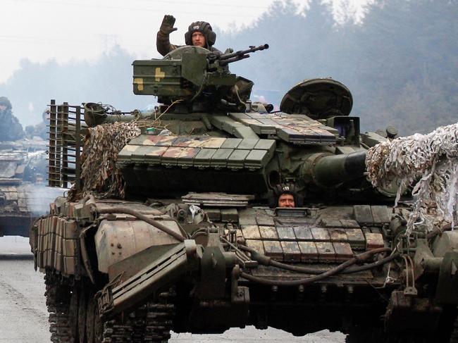 Ukrainian servicemen ride on tanks towards the front line with Russian forces. Picture: Anatolii Stepanov/AFP