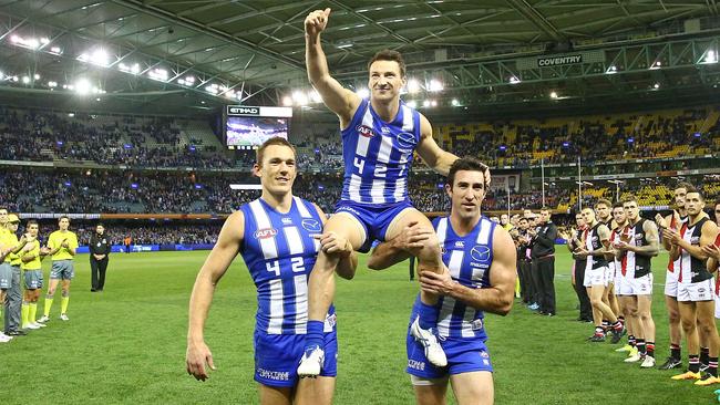 Brent Harvey is chaired off the ground by Drew Petrie and Michael Firrito after his AFL games record-breaking game in July. Picture: Getty