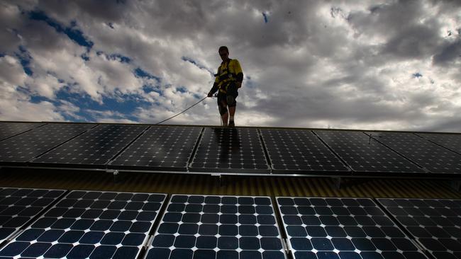 A territory worker installing Solar panels as Jacana energy lowers the solar feed in tariff to 8c, further disincentivising the up take of home solar in the NT.Picture GLENN CAMPBELL