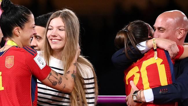 Spain's defender #20 Rocio Galvez is congratuled by President of the Royal Spanish Football Federation Luis Rubiales (R) next to Spain's Jennifer Hermoso after winning the Australia and New Zealand 2023 Women's World Cup final football match between Spain and England at Stadium Australia in Sydney on August 20, 2023. The Spanish football federation (RFEF) on August 26, 2023 threatened to take legal action over Women's World Cup player Jenni Hermoso's "lies" about her kiss with its president Luis Rubiales. (Photo by FRANCK FIFE / AFP)