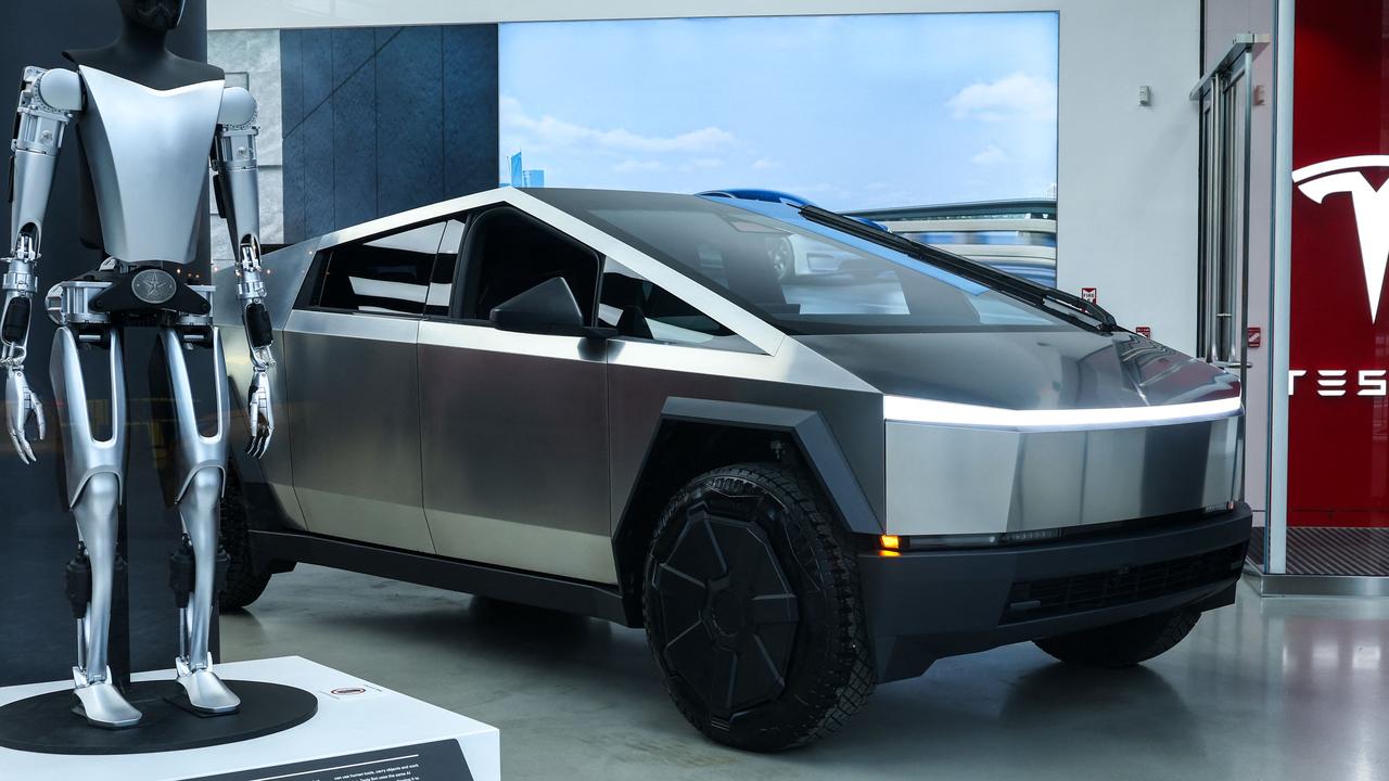 A Tesla Bot and a Tesla Cybertruck are seen in a Tesla showroom in New York City on February 16, 2025. (Photo by CHARLY TRIBALLEAU / AFP)