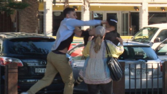 Max Towns appears to throw punches at Daily Telegraph photographer Dylan Robinson. AAP: Andrew Leeson