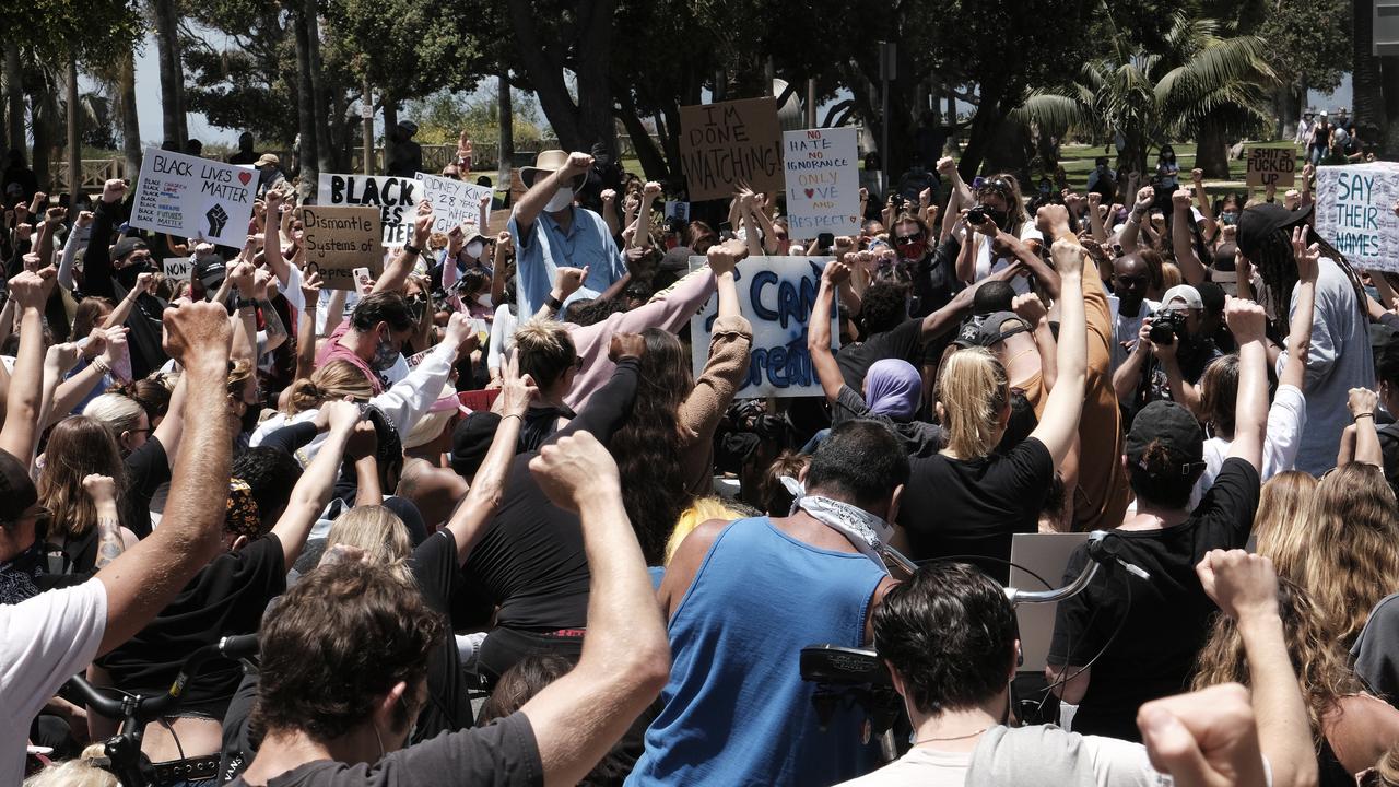 Protesters raise their fists and take to their knees in prayer during a Black Lives Matter protest. Picture: AP