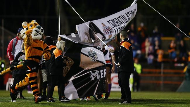 Aaron Woods attempts to run through a banner for his 100th game but fails to break it. Picture: Brett Costello