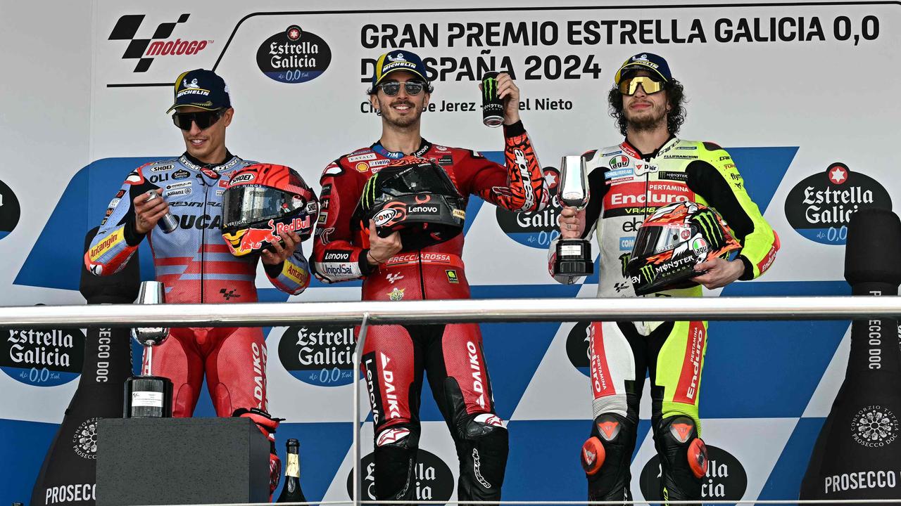 Second-placed rider Marc Marquez, winner Francesco Bagnaia and third-placed rider Marco Bezzecchi celebrate on the podium. (Photo by JAVIER SORIANO / AFP)
