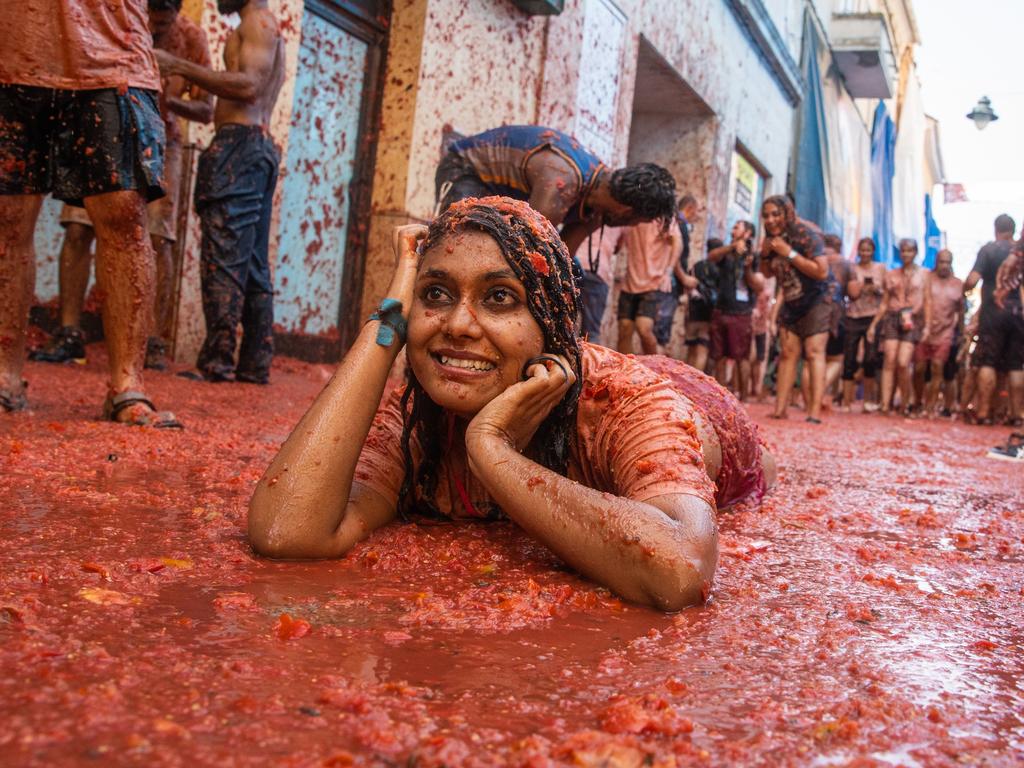 BUNOL, SPAIN - AUGUST 31: A reveler lays is tomato pulp during the Tomatina festival on August 31, 2022 in Bunol, Spain. The world's largest food fight festival, La Tomatina, consists of throwing overripe and low-quality tomatoes at each other. (Photo by Zowy Voeten/Getty Images)