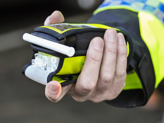 Belfast, Northern Ireland. 24 Nov 2016 - A police officer holds a roadside breathalyser alcohol breath test after taking a sample from a driver.