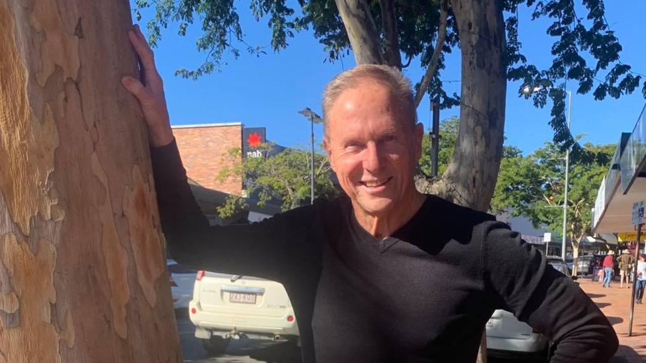 Gympie Chamber of Commerce president Tony Goodman in Mary St with the two leopard trees the Gympie council plans to remove.