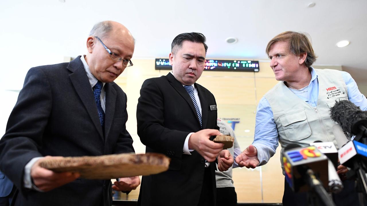 Malaysia Transport Minister Anthony Loke (centre) holds a piece of debris believed to be from Malaysian Airlines flight MH370. Picture: Mohd Rasfan/AFP