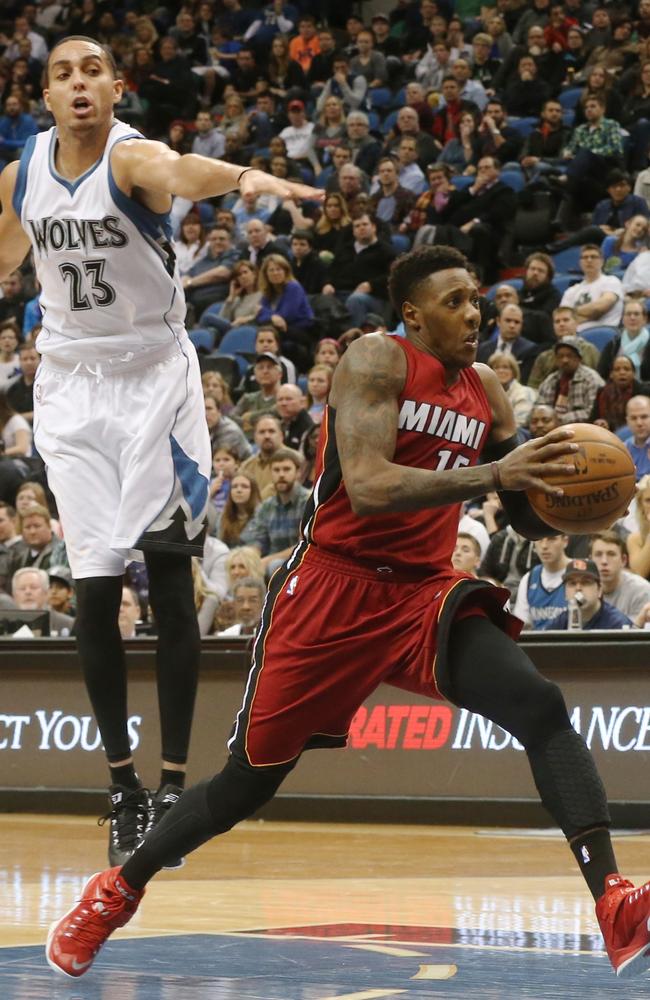 Minnesota Timberwolves’ Kevin Martin, left, jumps as Miami Heat’s Mario Chalmers races toward the basket.