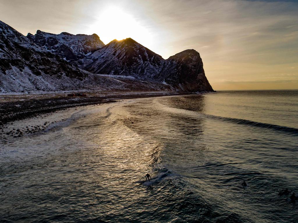 A surfer rides a wave on March 10, 2018 in Unstad, northern Norway, Lofoten islands, within the Arctic Circle as air temperature drops minus 13°C and water temperature above 4°C. Picture: AFP