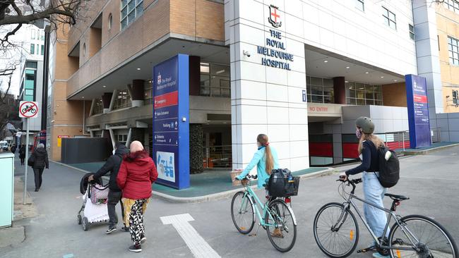 Residents walks past the Royal Melbourne Hospital in July. Picture: David Crosling