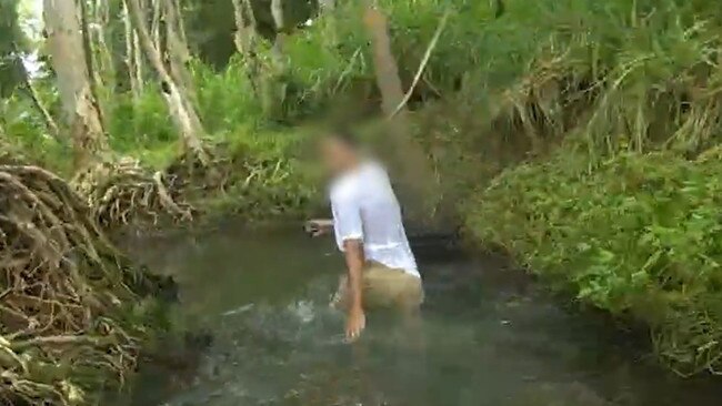 An alleged youth offender absconds from Task Force Guardian officers through a Cairns creek. Picture: Queensland Police