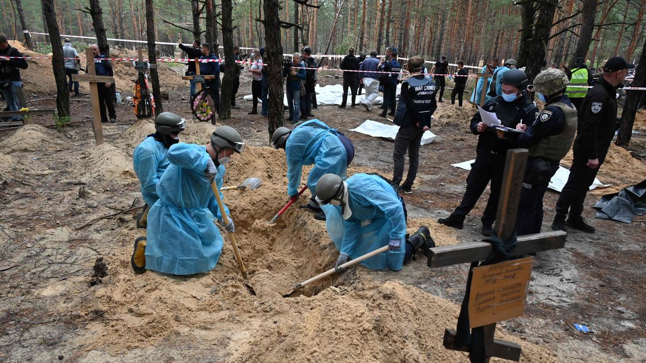 Officials dig a grave in a forest on the outskirts of Izyum. Picture: Sergey Bobok/ AFP.