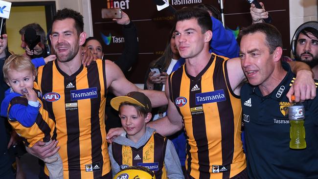 Jaeger O’Meara has trouble singing the club between Luke Hodge and coach Alastair Clarkson. Picture: AAP