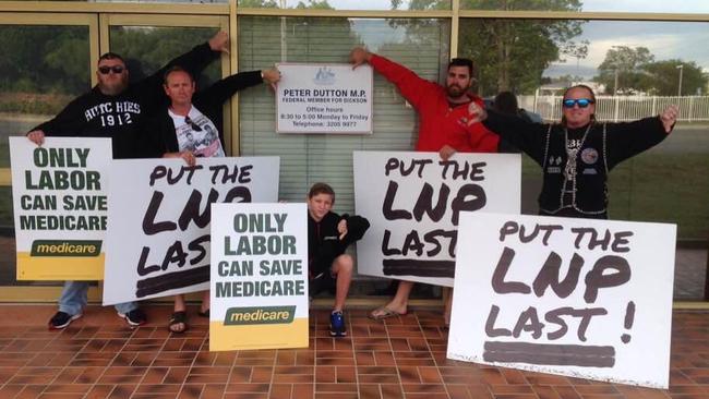 Labor supporters, including one wearing the colours of the Rebels bikie gang (right), outside the office of Immigration Minister Peter Dutton.