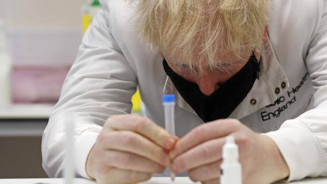 Boris Johnson looks at a coronavirus test sample at Porton Down. Picture: Getty Images.