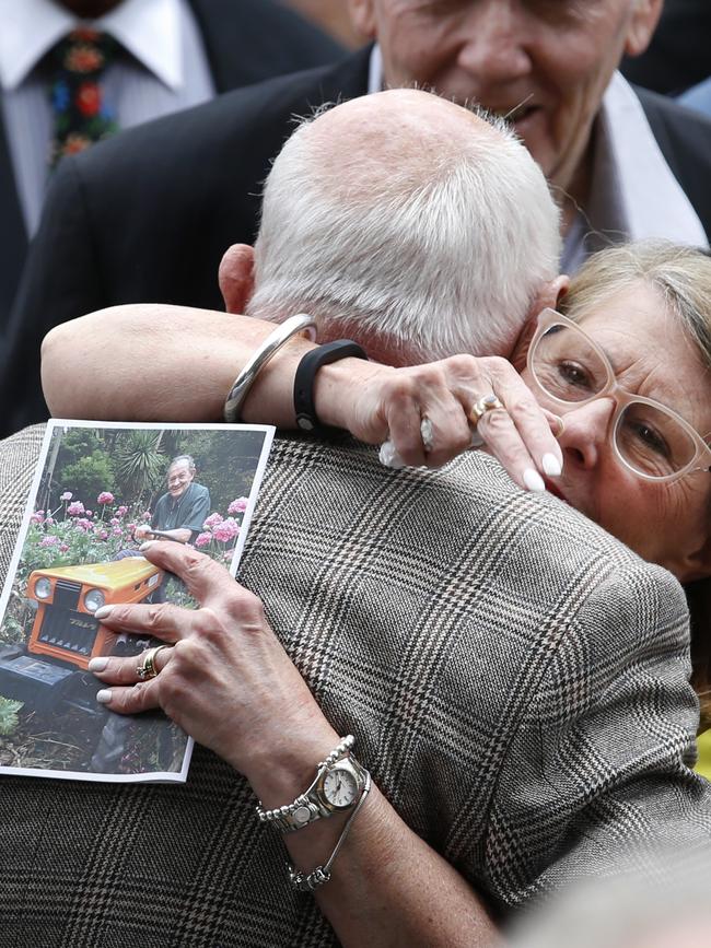 A mourner hugs co-owner of Pellegrini's Espresso Bar Nino Pangrazio outside after the service. Picture: David Caird