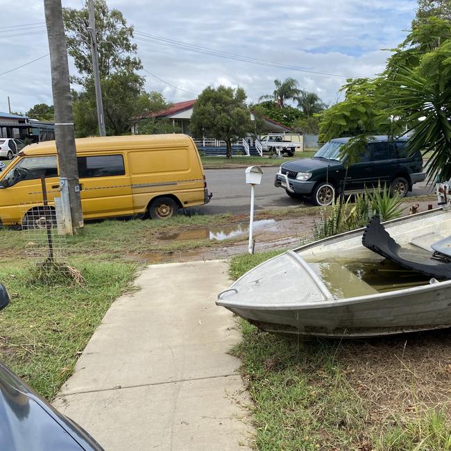 Eight hours after the torrential rain subsided, a Moura Cr resident was still assessing the damage with a flood line visible on the boat and yellow van. Picture: Nilsson Jones