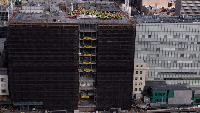 More than 500 construction workers gather on the top of the Royal Hobart Hospital K-Block after the main concrete structure was completed this month.