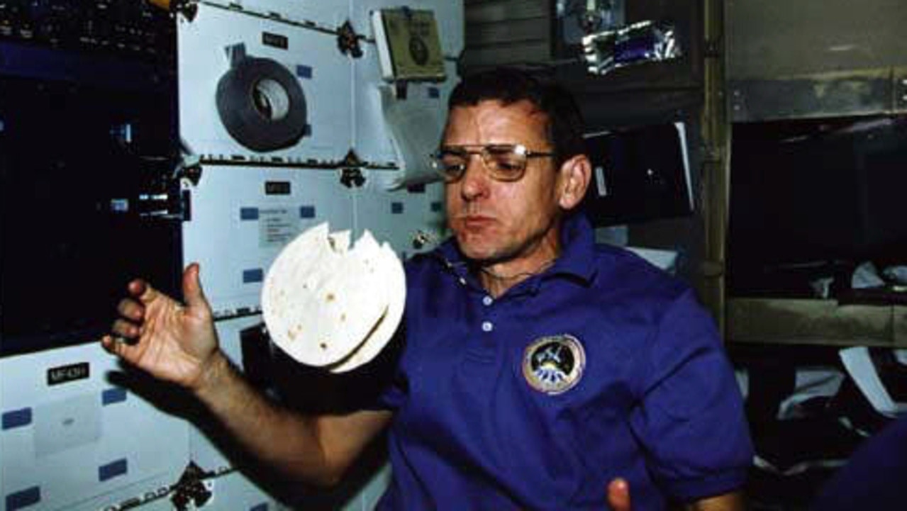 SPACE SERIES: Astronaut William McArthur eating his favorite space-sandwich - a sausage patty, scrambled eggs and cheese spread between two floating tortillas.  food