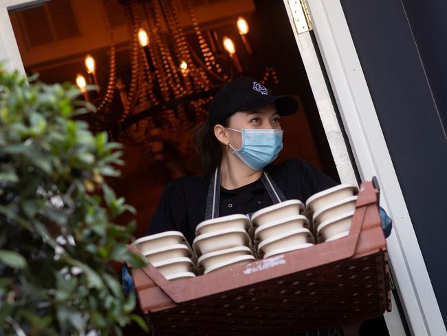 A volunteer carries a tray of prepared free meals to a truck for distribution to NHS staff, key workers and vulnerable people, outside a restaurant in Fulham, south west London. Picture: AFP