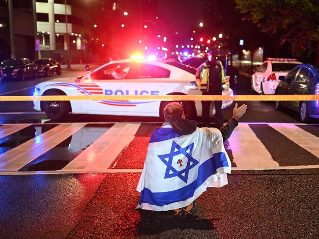 A man draped in the Israeli flag, bearing a cross and the name 