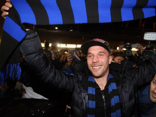 German forward Lukas Podolski holds up an Inter Milan scarf as he arrives at the Linate airport, Milan, Italy, Friday, Jan. 2, 2015. Podolski is joining the Serie A club Inter Milan. (AP Photo/Ansa/Matteo Bazzi)