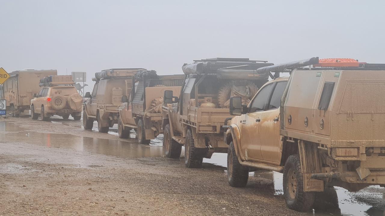 Mud-covered cars line up at Big Red Bash after an outback deluge. Photo: Danica Clayton