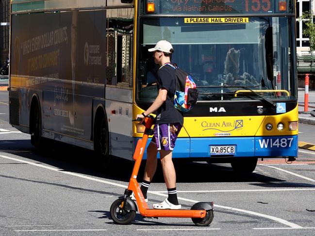 An e-scooter rider without a helmet in Brisbane’s CBD. Picture: David Clark