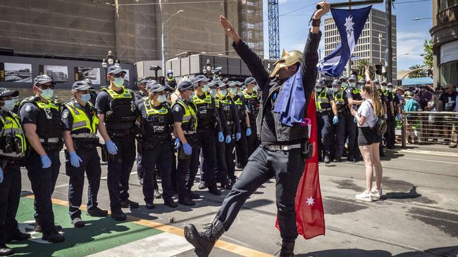 A protester gives the Hitler salute while goose stepping in front of police lines. Picture: Jake Nowakowski