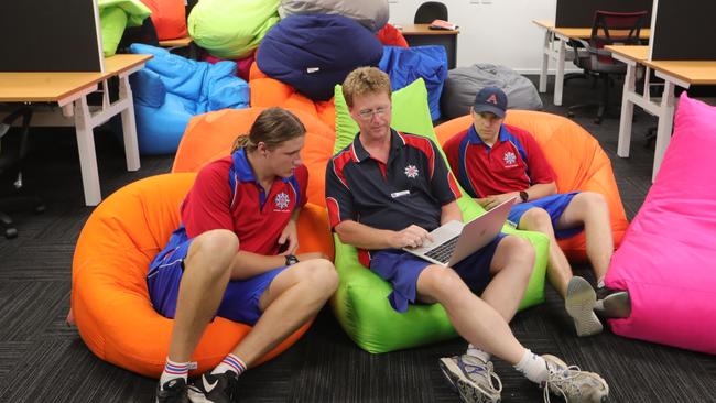  Gone are the days of the desk, these kids are living in a hot desk world. Roma Tuivasa 15 and Ivana Loleiso 15 working on their laptops at Aquinas College with teacher Craig Heufel. Picture Glenn Hampson