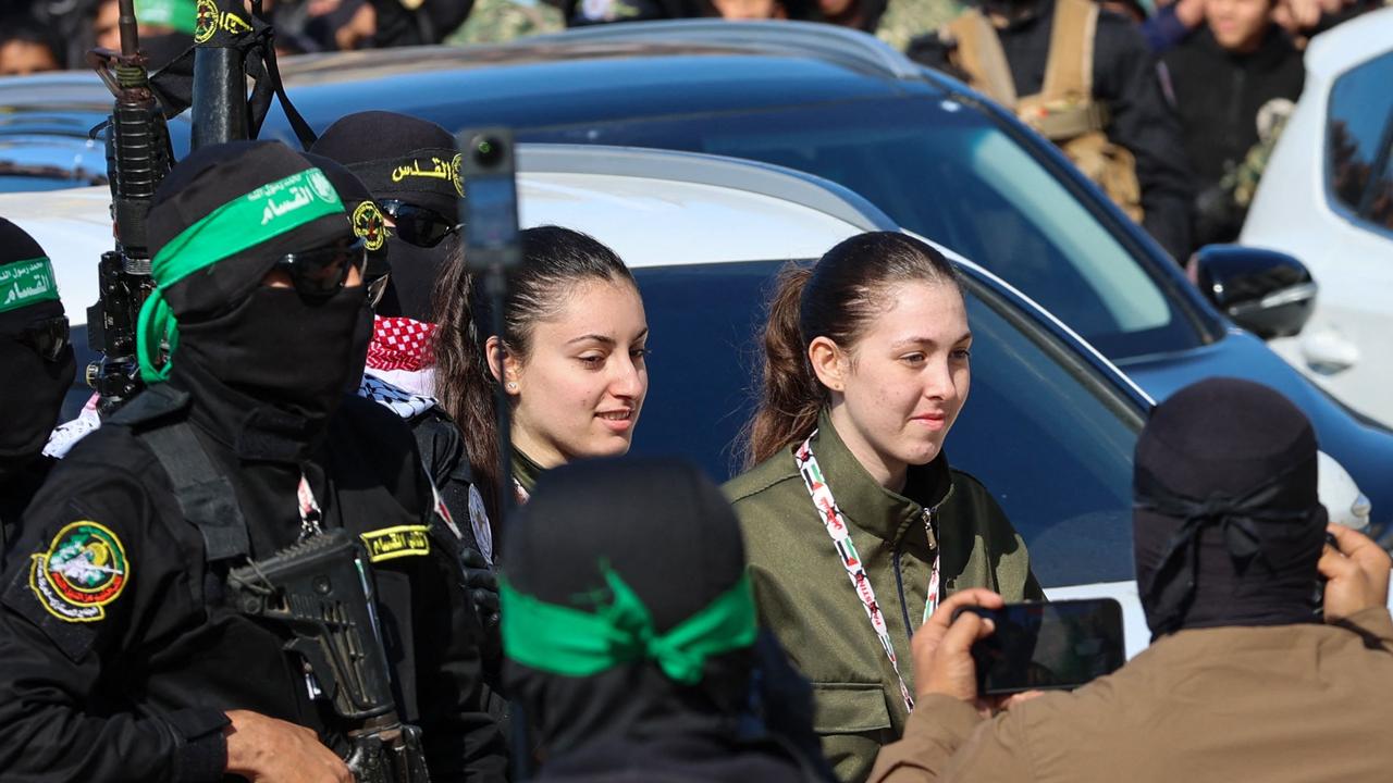 Hamas fighters escort four Israeli hostages to hand them over. Picture: Omar AL-QATTAA / AFP