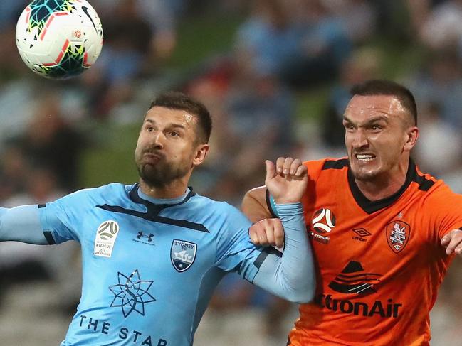 Kosta Barbarouses of Sydney FC and Brisbane Roar skipper Tom Aldred in December.