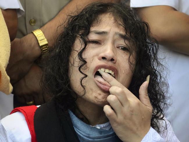Indian political activist Irom Sharmila licks honey from her hand to break her fast in Imphal, north-eastern Indian state of Manipur, India, Tuesday, Aug. 9, 2016. One of India's most prominent political activists ended a 16-year hunger strike Tuesday, licking honey from her hand and declaring 