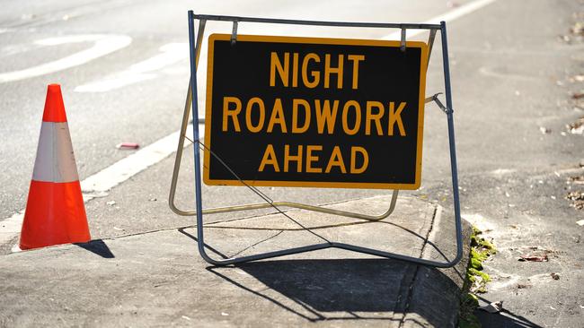 A sign warning of night roadwork ahead stands on the side of the road in Sydney on Tuesday, May 22, 2012. (AAP Image/Paul Miller) NO ARCHIVING