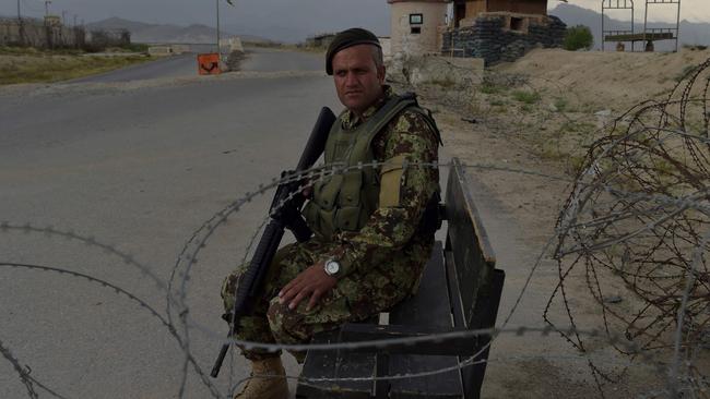 An Afghan soldier mans a checkpoint at the US military base at Bagram where helicopters and cargo planes have been active all week. Picture: AFP