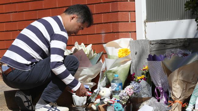 A man lays flowers near the site of a fatal house fire in Glen Waverley where a woman and her three children were killed. Monday, January 11, 2020. Picture: David Crosling