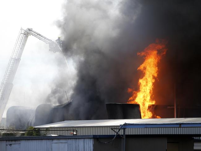 Fire fighters using a crane to contain the blaze. Picture: Richard Dobson