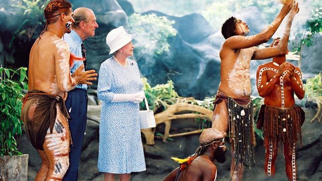 Queen Elizabeth and Prince Philip watch Warren Clements of the Tjapukai Aboriginal dancers make fire. Picture: Anna Brevitt.