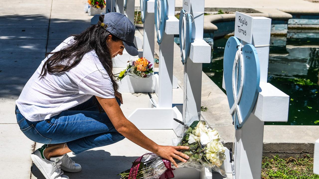 Britain's Meghan, Duchess of Sussex, places flowers as she mourns at a makeshift memorial outside Uvalde County Courthouse in Uvalde. Picture: CHANDAN KHANNA / AFP