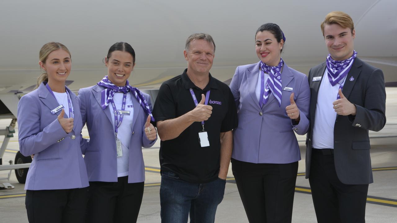 Bonza CEO Tim Jordan (centre) with members of the cabin crew at the first flight by the carrier from Melbourne to Toowoomba Wellcamp Airport.