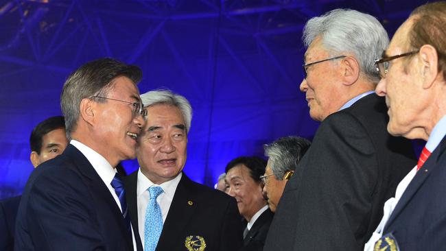 South Korea's President Moon Jae-in, left, shakes hands with a North Korean delegation led by International Olympic Committee member Chang Ung at the World Taekwondo Championships.