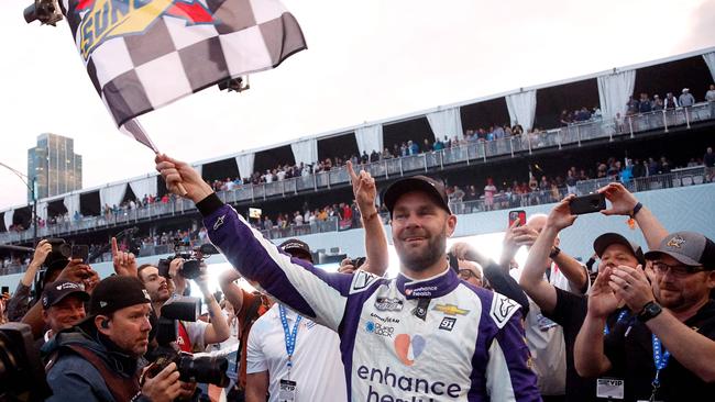 Shane van Gisbergen celebrates with the checkered flag after winning at the Chicago Street Course. Photo: Sean Gardner/Getty Images