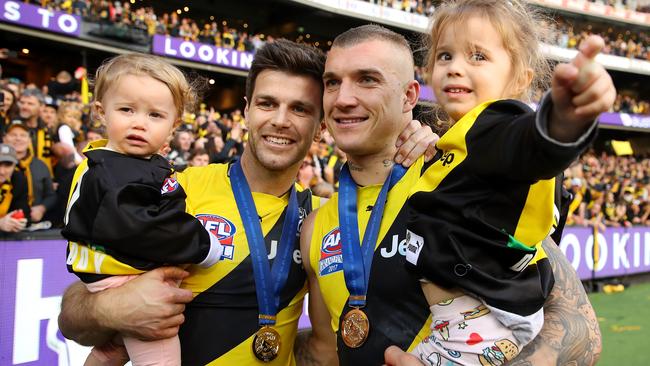 Trent Cotchin of the Tigers and Dustin Martin of the Tigers pose with Cotchins daughters