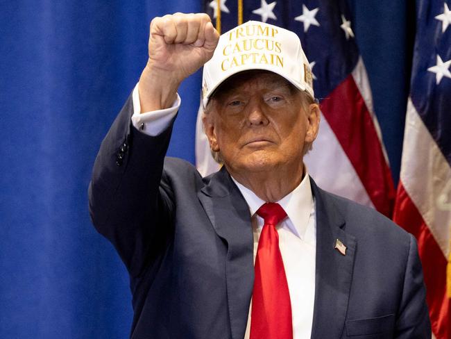 TOPSHOT - Former US President and 2024 Republican presidential hopeful Donald Trump raises his fist at a âCommit to Caucusâ event at Simpson College in Indianola, Iowa, on January 14, 2024. (Photo by Christian MONTERROSA / AFP)