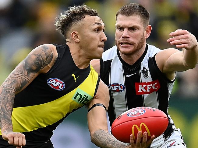 MELBOURNE, AUSTRALIA - MAY 07: Shai Bolton of the Tigers handballs whilst being tackled by Taylor Adams of the Magpies during the round eight AFL match between the Richmond Tigers and the Collingwood Magpies at Melbourne Cricket Ground on May 07, 2022 in Melbourne, Australia. (Photo by Quinn Rooney/Getty Images)